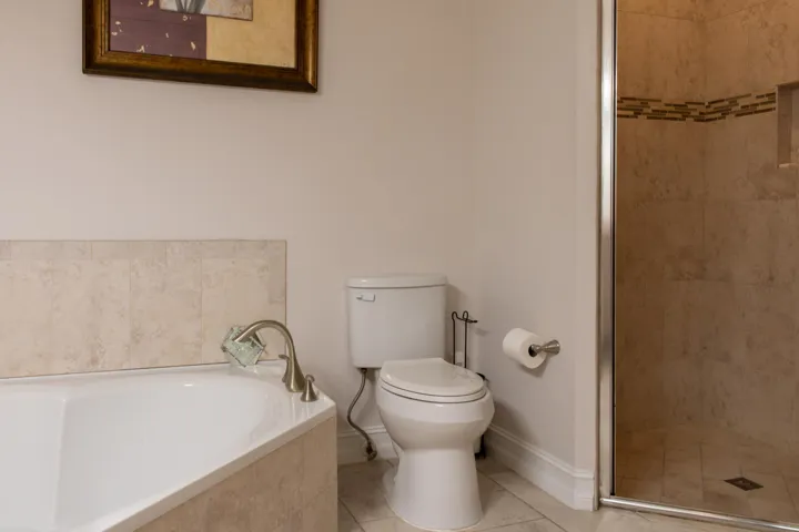 Corner soaking tub with tile surround and brushed nickel faucet