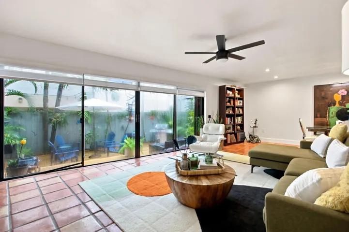 Expansive sliding glass doors open to a private outdoor space featuring a privacy fence