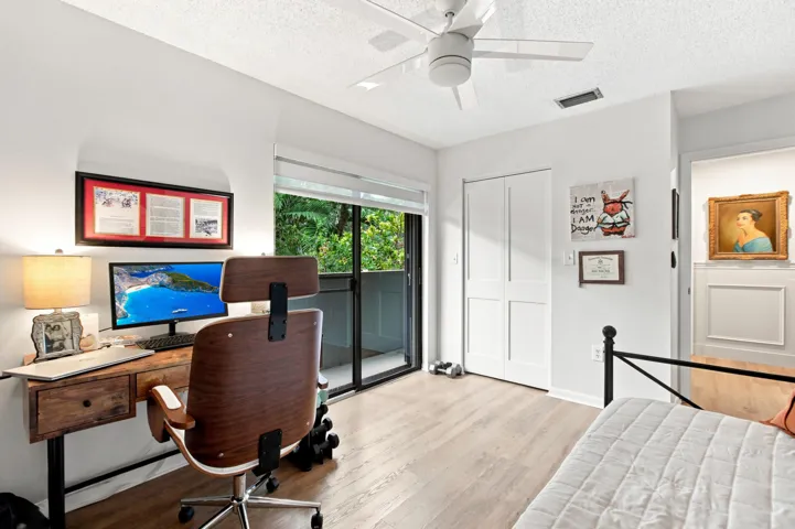 Spacious room featuring wood-finish flooring, a ceiling fan, and built-in closet with bi-fold doors