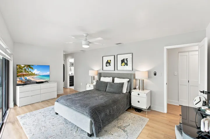 Bedroom featuring wood-finish flooring, a ceiling fan with integrated lighting, and light gray wall paint