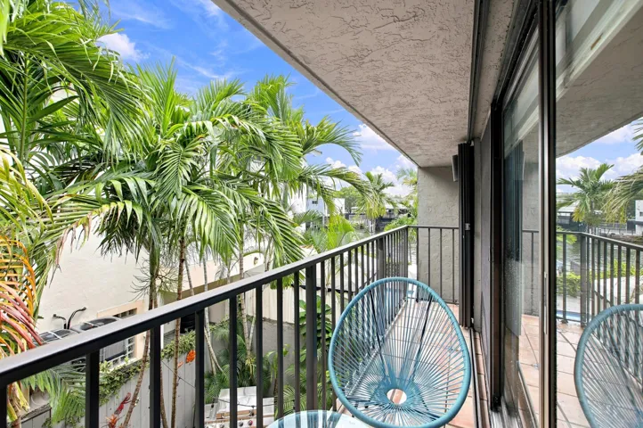 Private balcony featuring a black metal railing and large sliding glass doors and side view of river.
