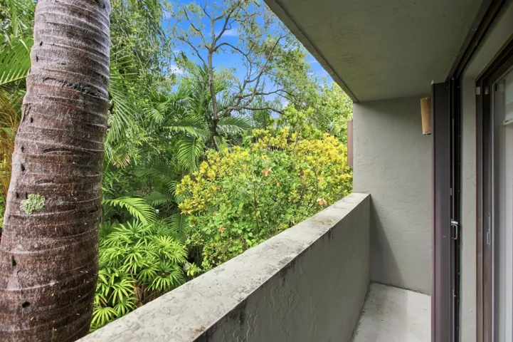 Private balcony featuring a concrete railing, stucco wall finish, and a sliding glass door