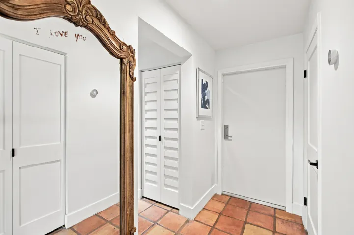 Entryway featuring terracotta tile flooring and white baseboards