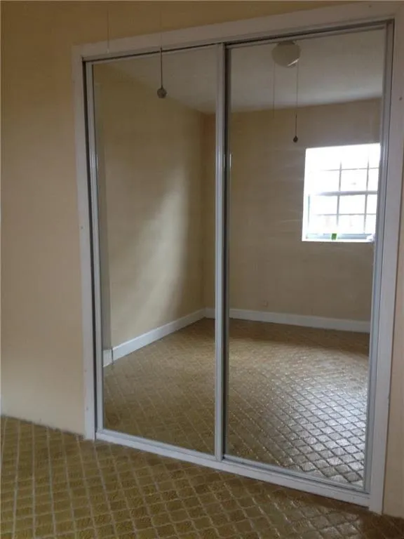 Mirrored sliding closet doors with white trim and a neutral wall color