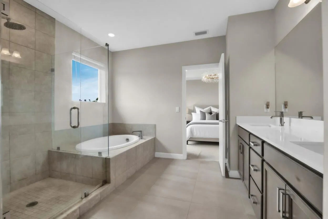 The master bathroom feels like a private spa with a large glass-enclosed shower, separate soaking tub, and dual vanities.