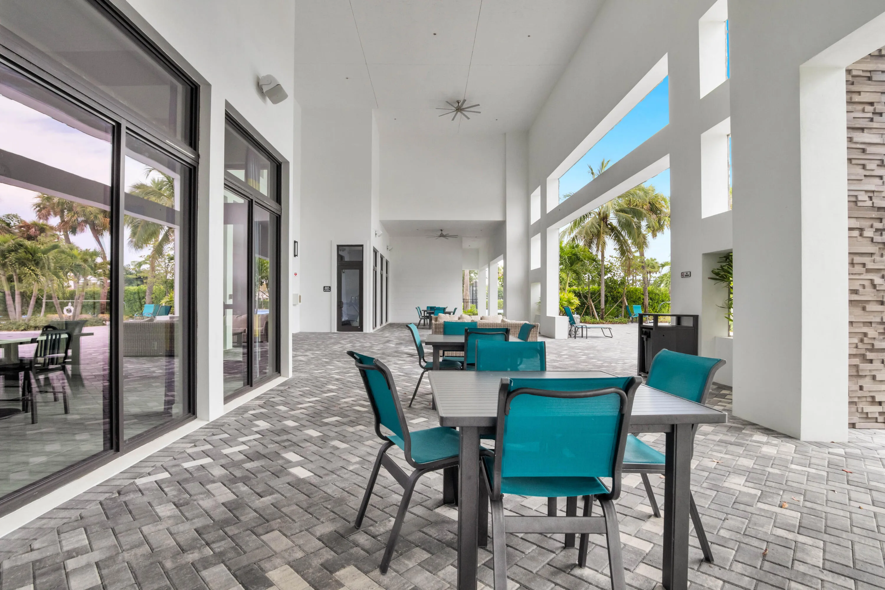 Spacious covered outdoor lounge area sits just steps from the pool, ideal for gatherings.