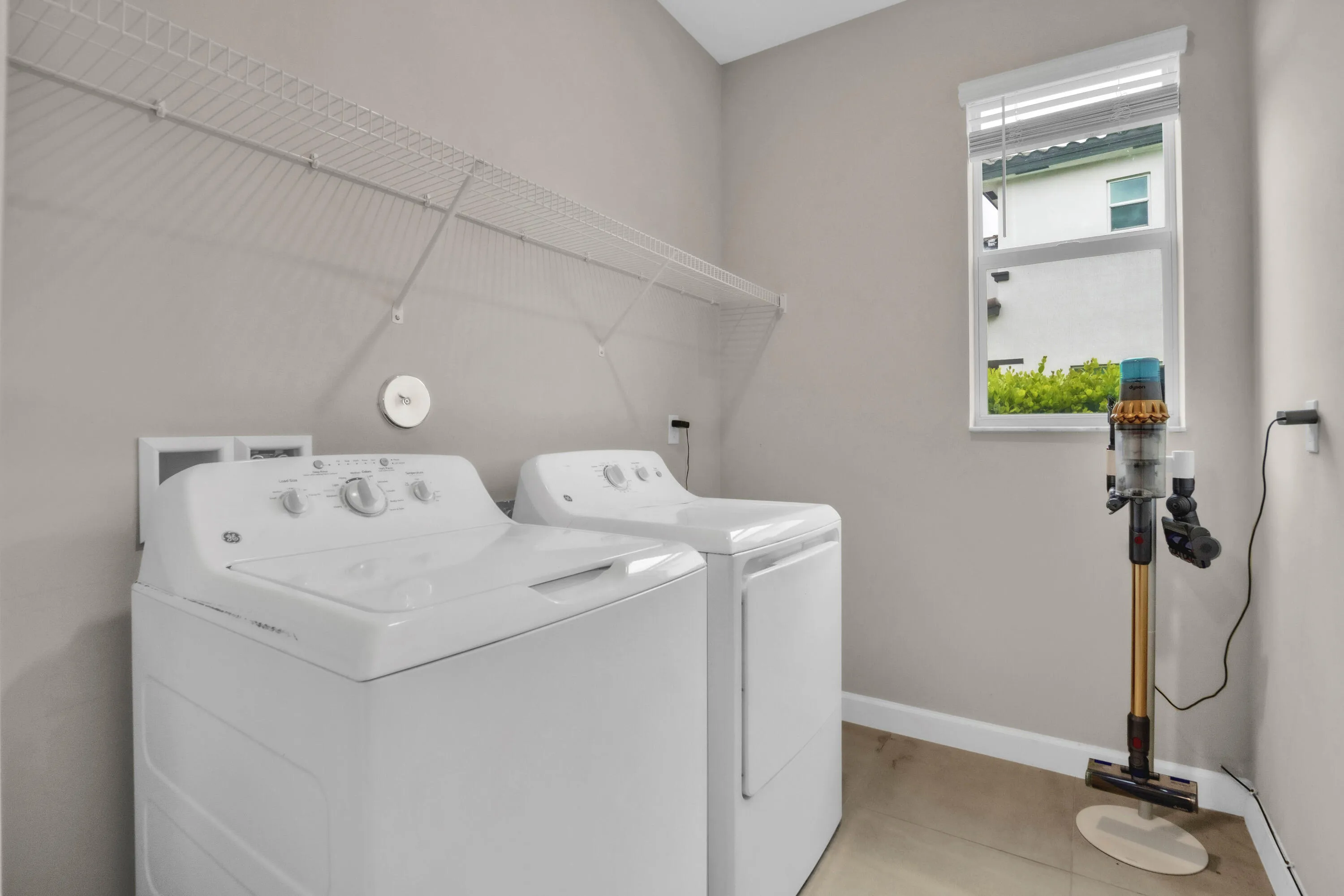 Dedicated laundry room with full-size washer and dryer keeps household chores simple and out of the way.