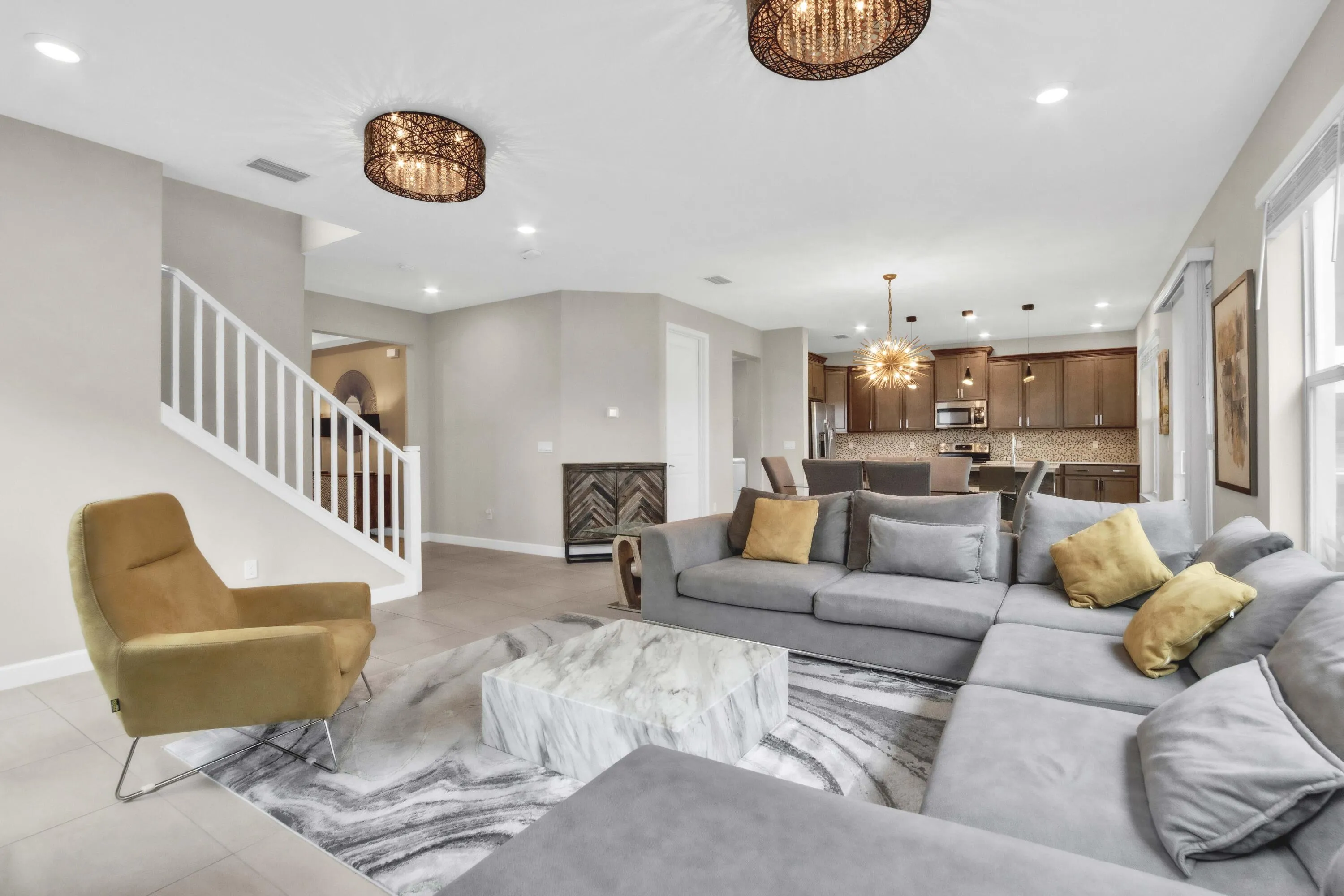 From the living space you can see the open flow into the kitchen and the staircase leading to the private upstairs bedrooms.