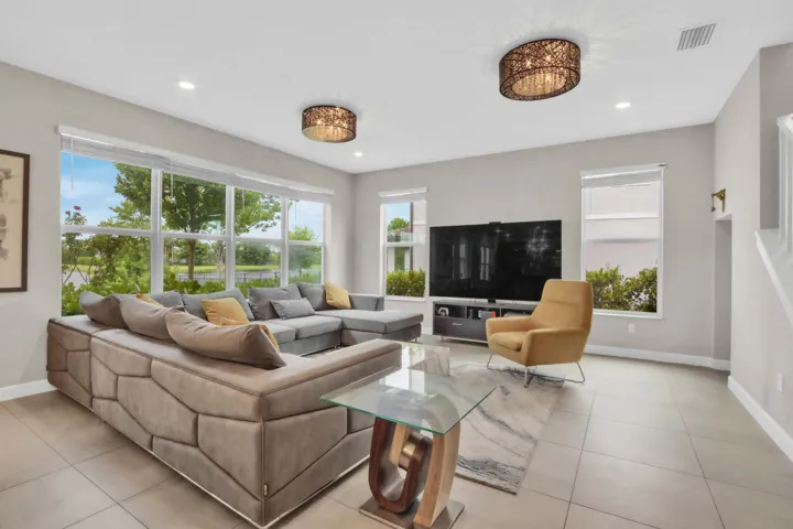 The heart of the home opens to a bright living space with walls of windows that frame peaceful water and green views.