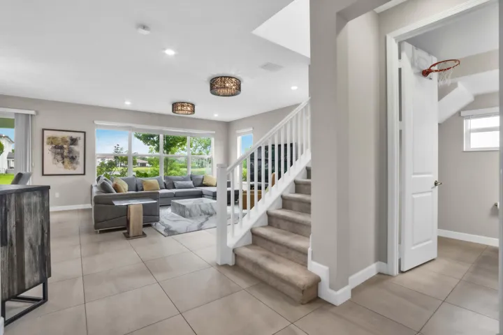 The open living area leads toward the staircase, inviting you upstairs to the private bedroom level.