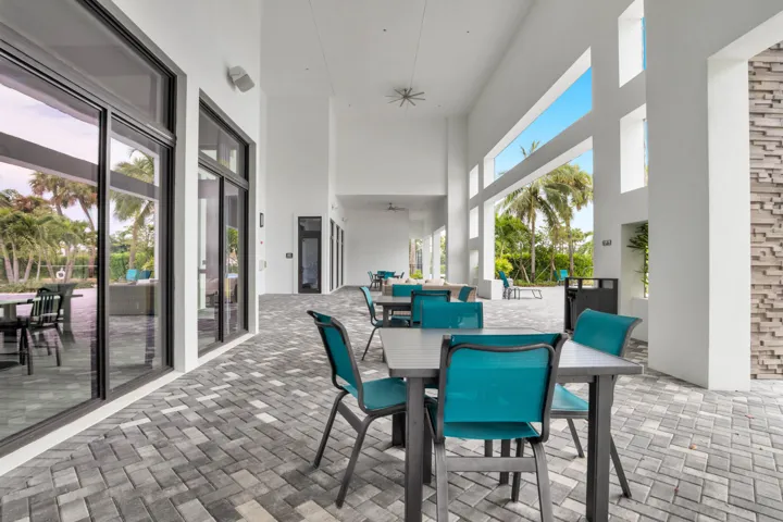 Spacious covered outdoor lounge area sits just steps from the pool, ideal for gatherings.