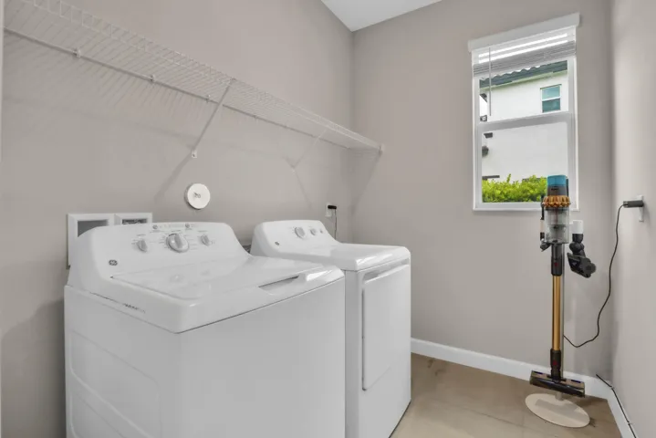 Dedicated laundry room with full-size washer and dryer keeps household chores simple and out of the way.