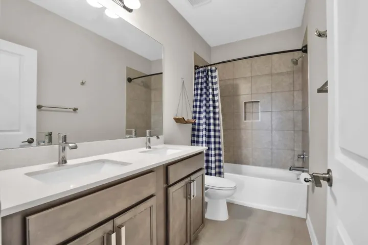 The shared upstairs bathroom includes dual sinks and a full tub/shower combination.
