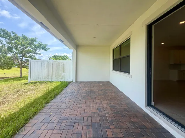 Covered patio featuring brick paver flooring and a sliding glass door entry