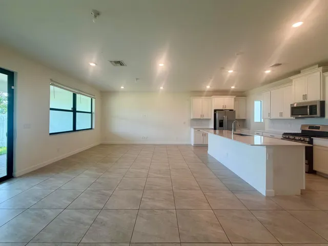 Expansive open-concept living area featuring large format tile flooring and recessed lighting