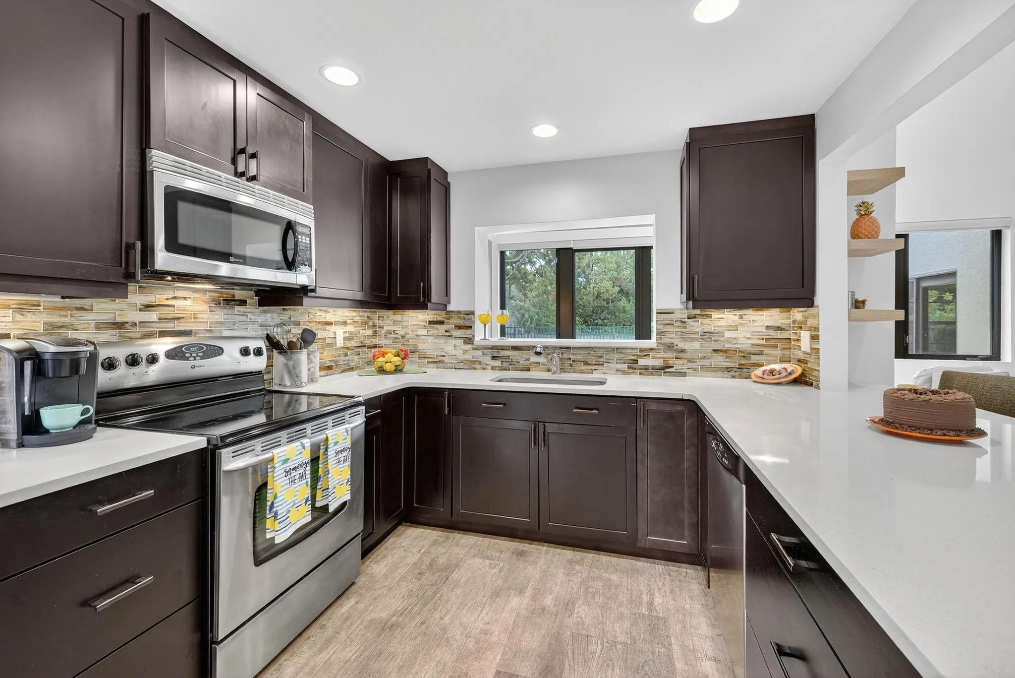 Full glass backsplash and rich coffee color cabinets.