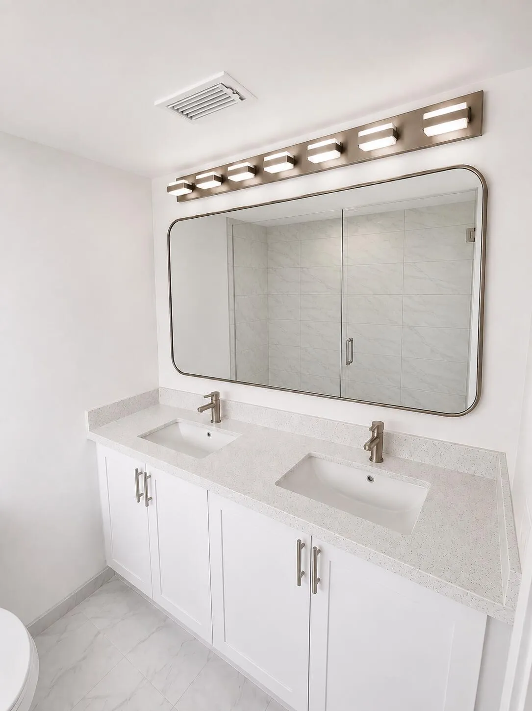 Double vanity with white cabinetry, light-toned countertops, and dual undermount sinks