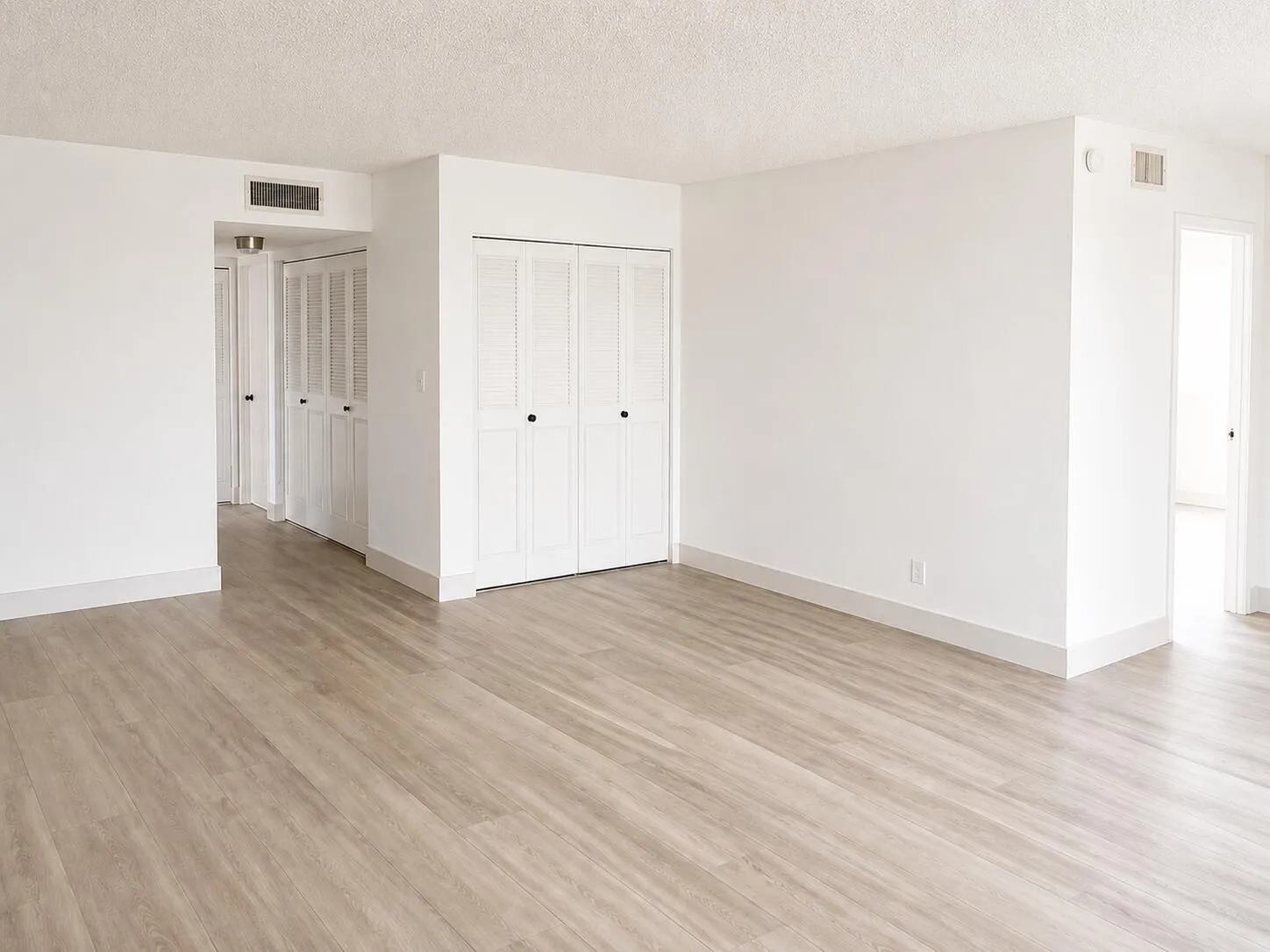 Light wood-finish flooring throughout, complemented by white walls and baseboards