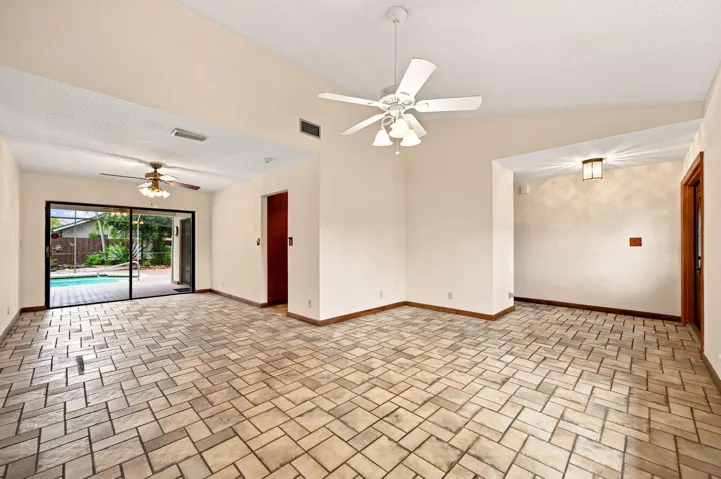 LIVING ROOM OPEN TO DINING AREA. NICE VIEW OF POOL AND PATIO.