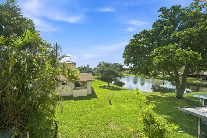 Expansive green lawn, mature trees, and a tranquil pond