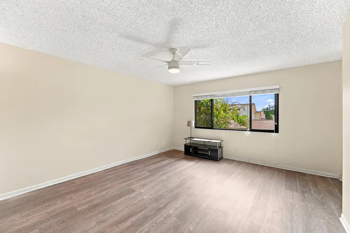 Wood-finish flooring throughout, complemented by a large window with roller shades