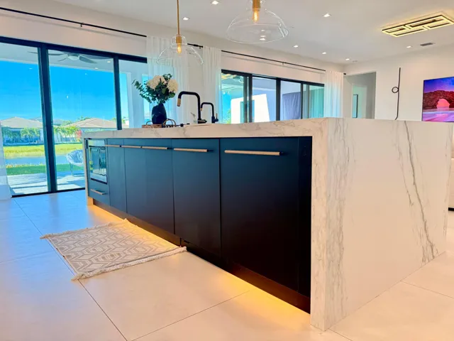 Fully redesigned kitchen showcasing Italian porcelain surfaces, an expanded statement island, custom cabinetry, and premium integrated lighting.