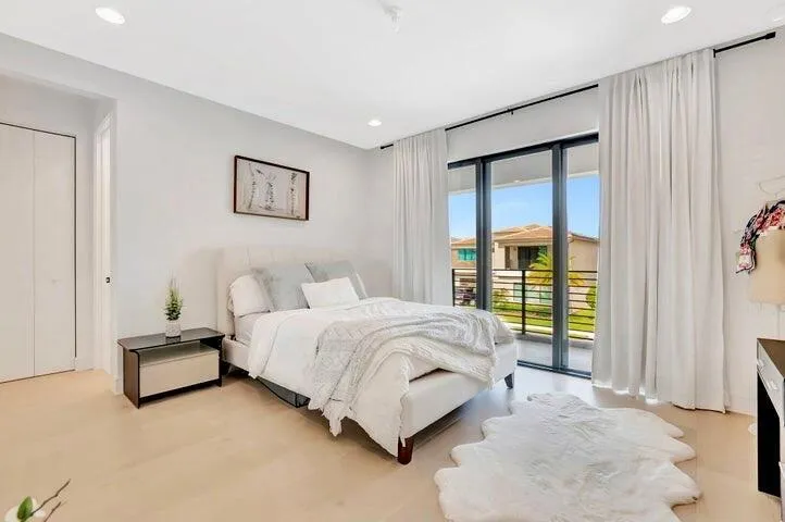 Comfortable bedroom with wide-plank flooring, recessed lighting, and a calm, neutral palette.
