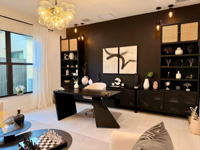 Custom built-in desk with integrated storage and display cabinetry, positioned opposite the office seating area.