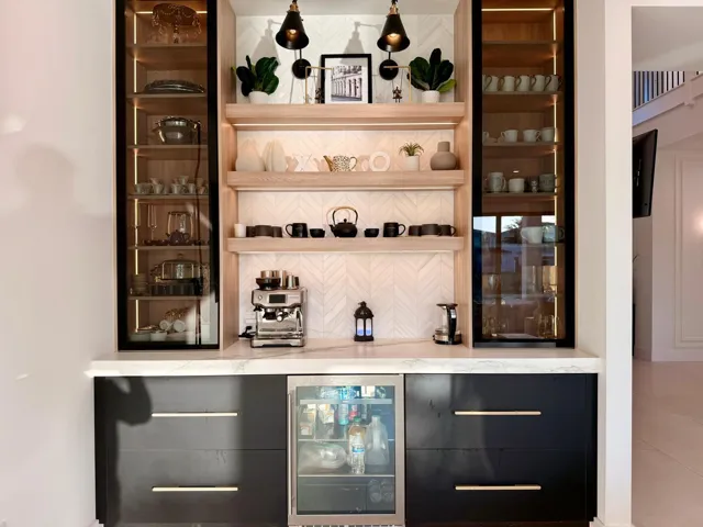 Custom built-in bar featuring integrated refrigeration, accent lighting, and display shelving—ideal for entertaining.