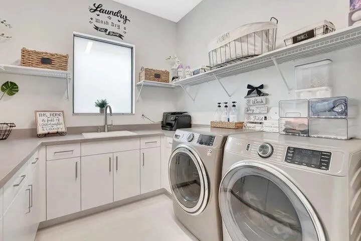 Well-appointed laundry room with custom cabinetry, ample counter space, and modern appliances.