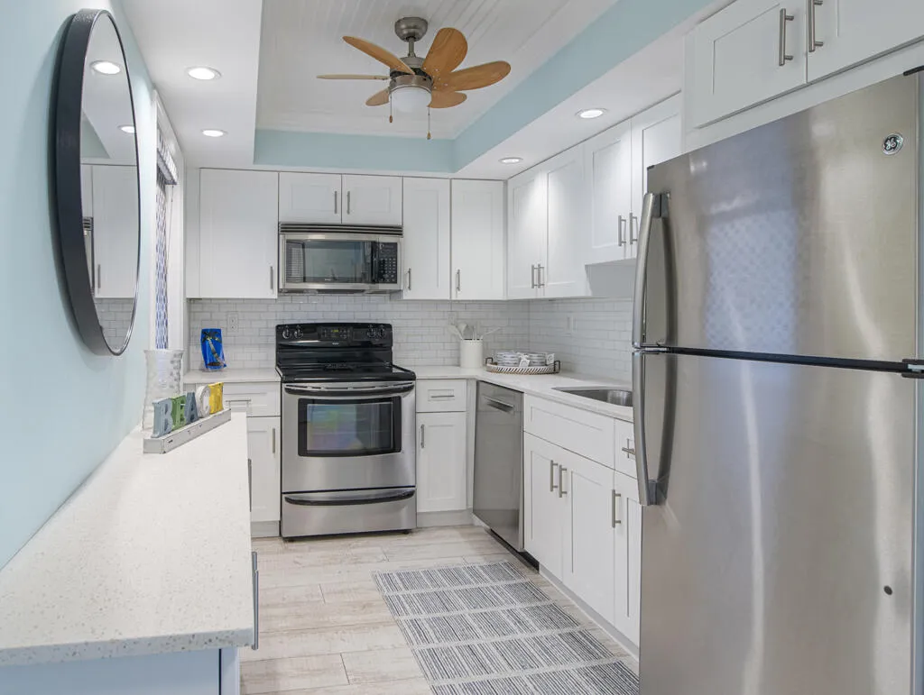 Bright kitchen featuring white shaker cabinetry and stainless steel appliances
