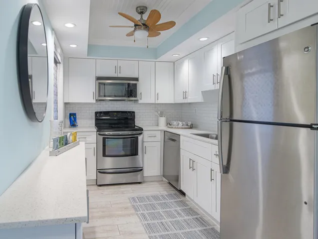 Bright kitchen featuring white shaker cabinetry and stainless steel appliances