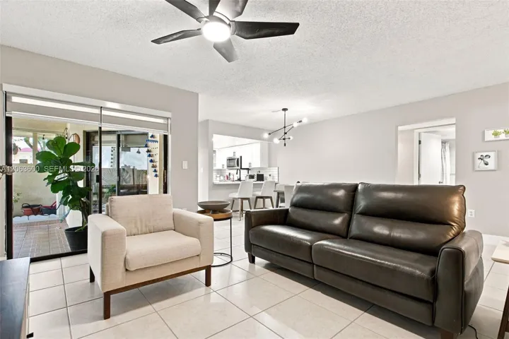 Living area open to the kitchen and dining space beyond, with sliding glass doors to the covered patio.