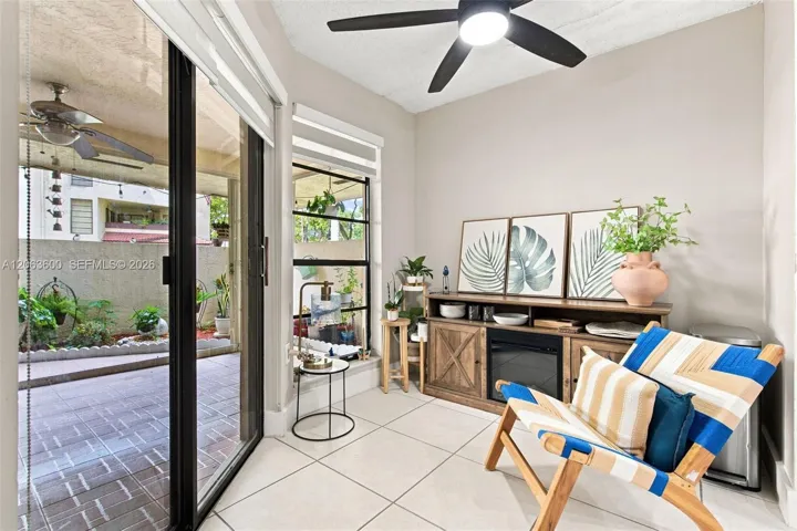 Enclosed patio with tile flooring, sliding glass doors, and view to the private paver patio outside.