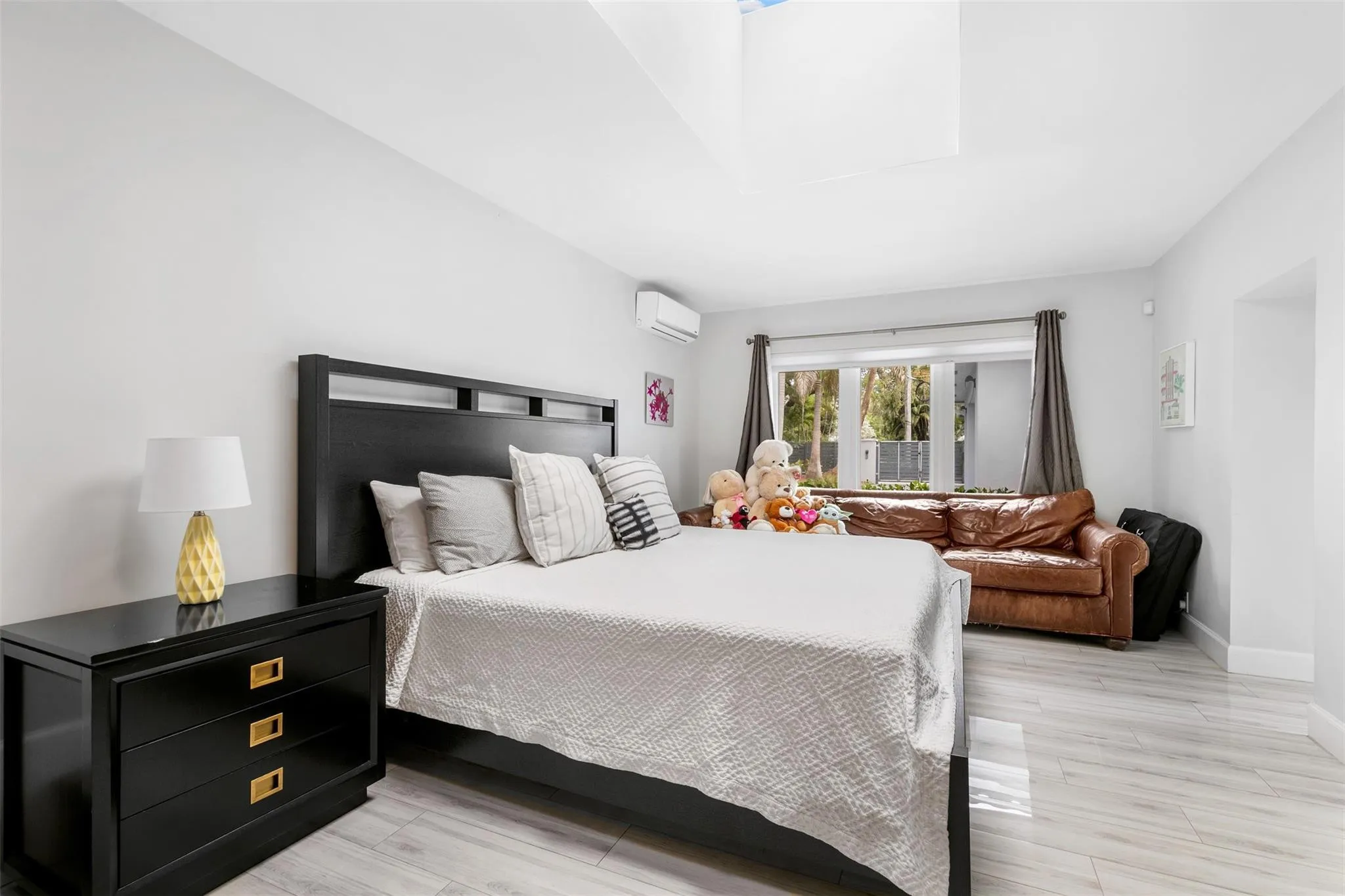 Spacious room featuring light wood-finish flooring, a contemporary window unit, and a large window with exterior views
