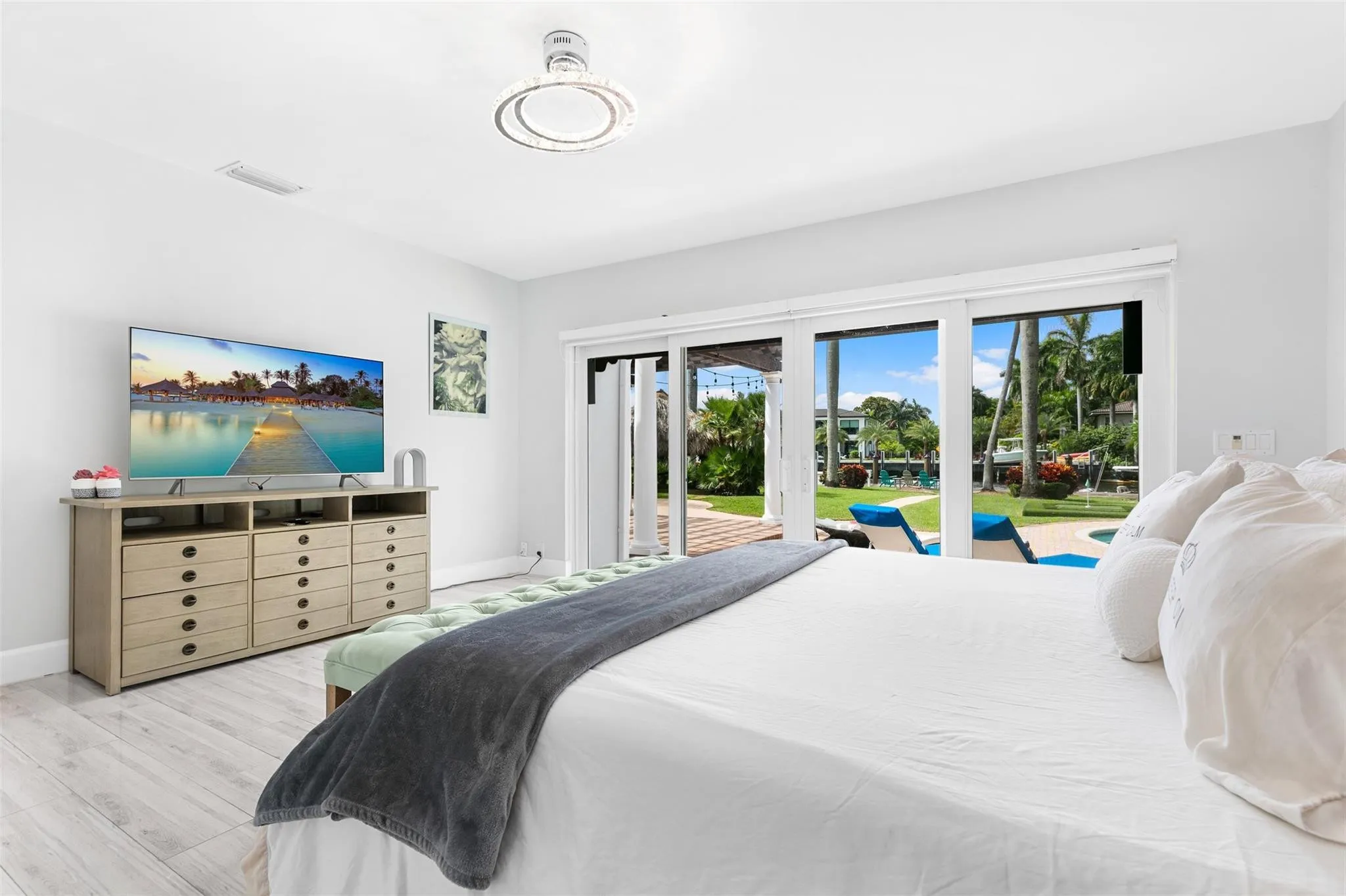 Spacious interior featuring light wood-finish flooring, white wall tones, and a modern ceiling light fixture