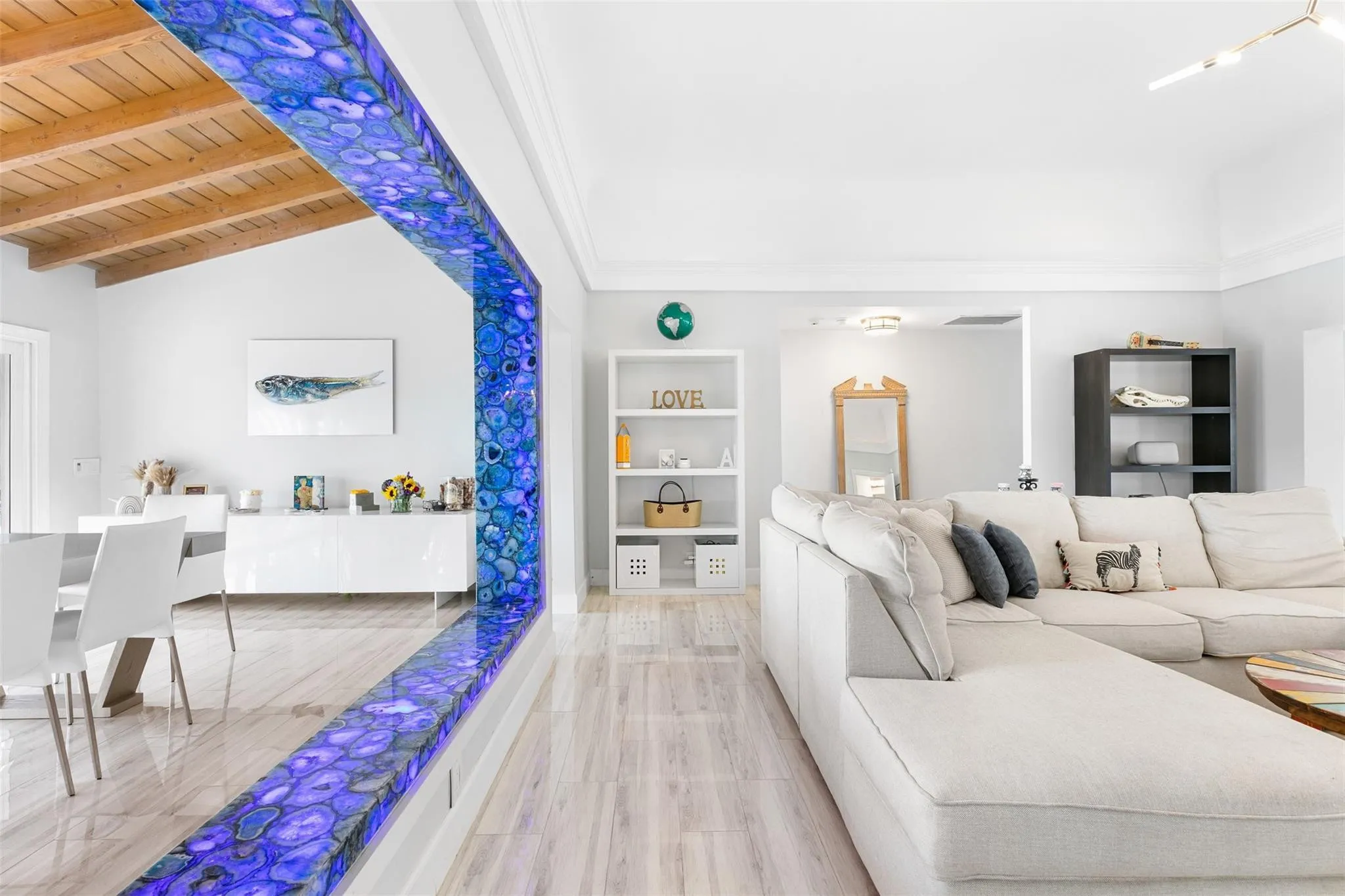 Open-concept living space featuring a distinctive illuminated dividing wall with a unique patterned inlay