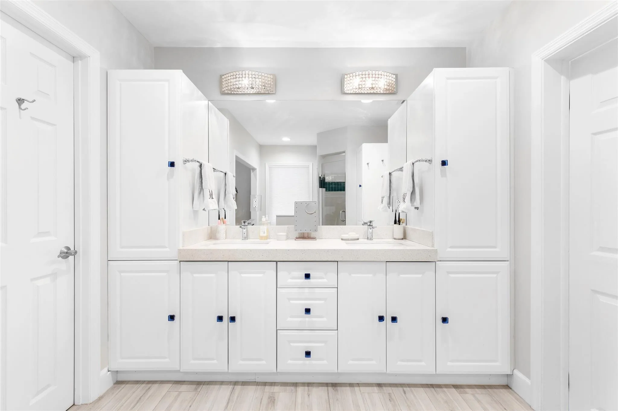 Double vanity with white cabinetry, light-toned countertop, dual sinks, and mirrored backsplash