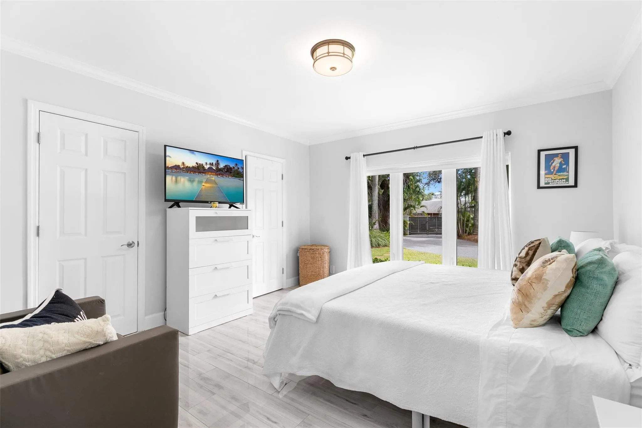 Bedroom featuring light-tone wood-finish flooring and crown molding