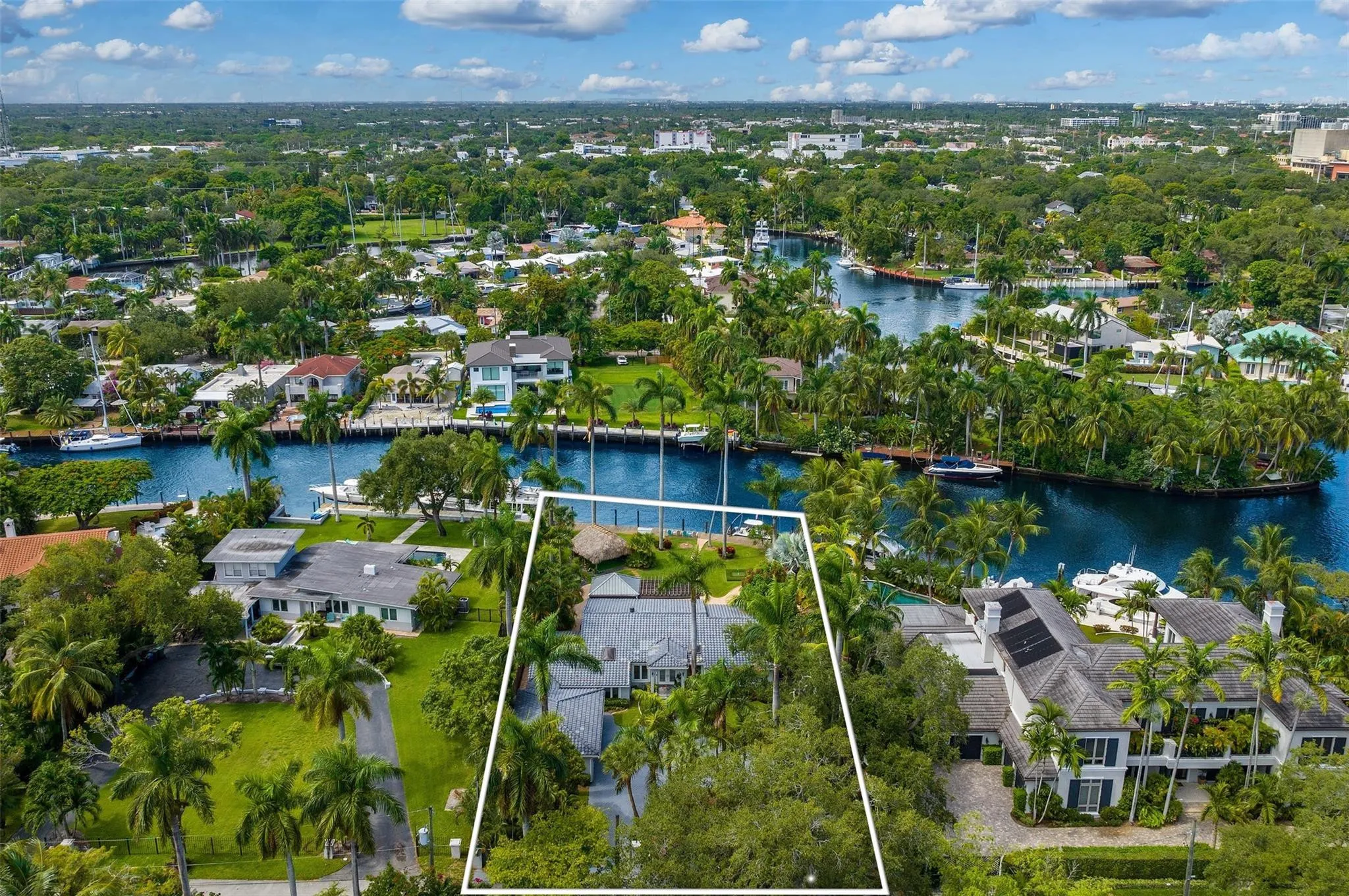 Expansive waterfront property featuring mature palm trees and lush landscaping