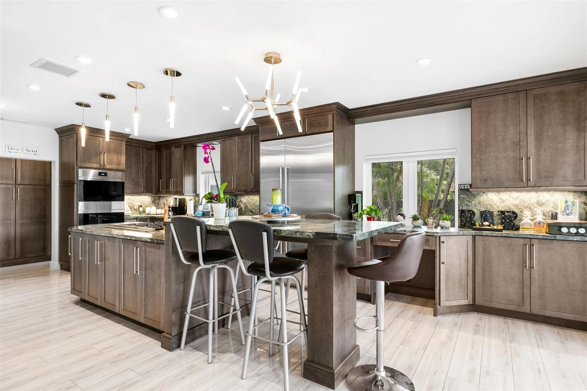 Contemporary kitchen featuring wood-finish cabinetry, stainless steel appliances, and contrasting countertops