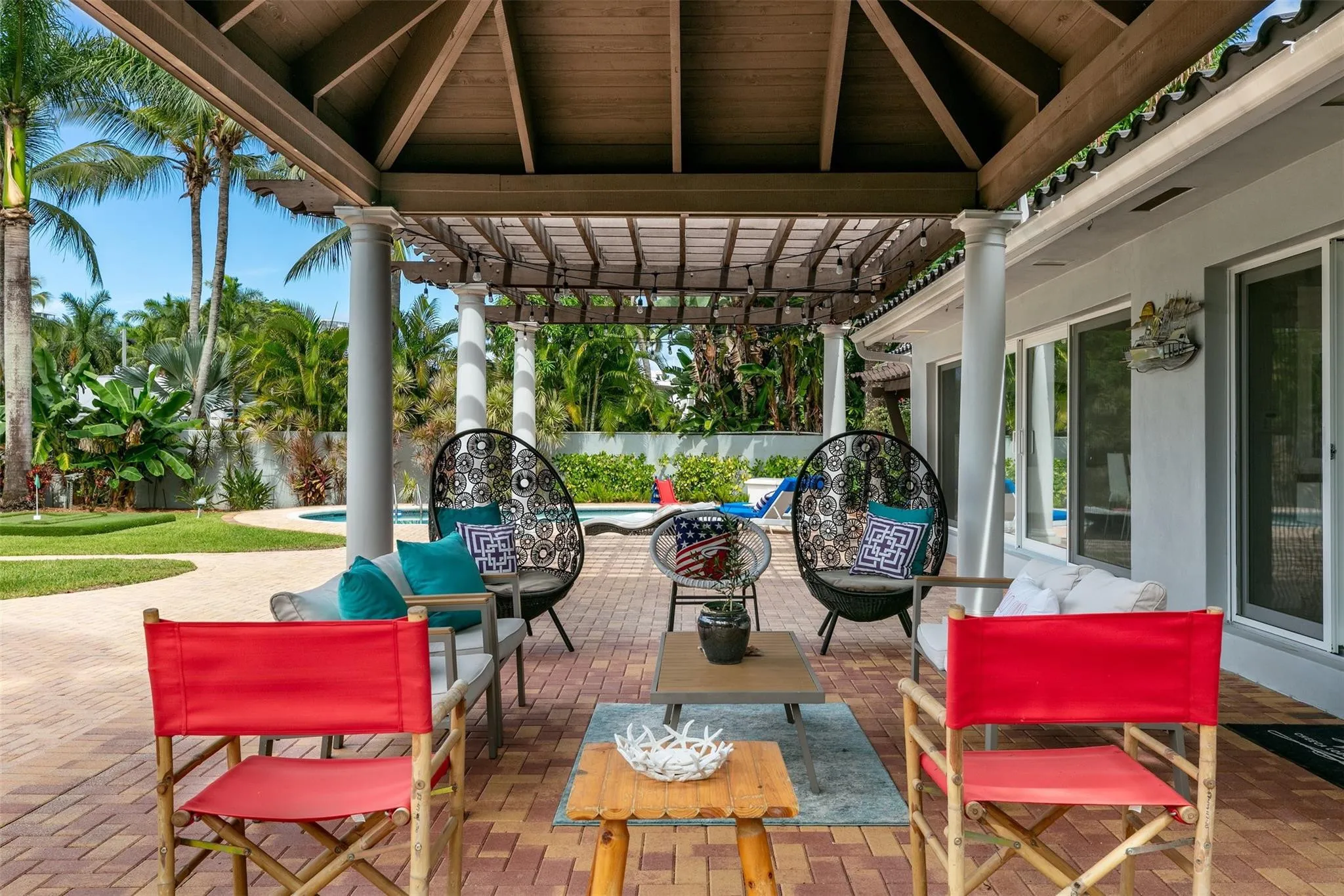 Covered patio with brick paver flooring, pergola, and exterior columns