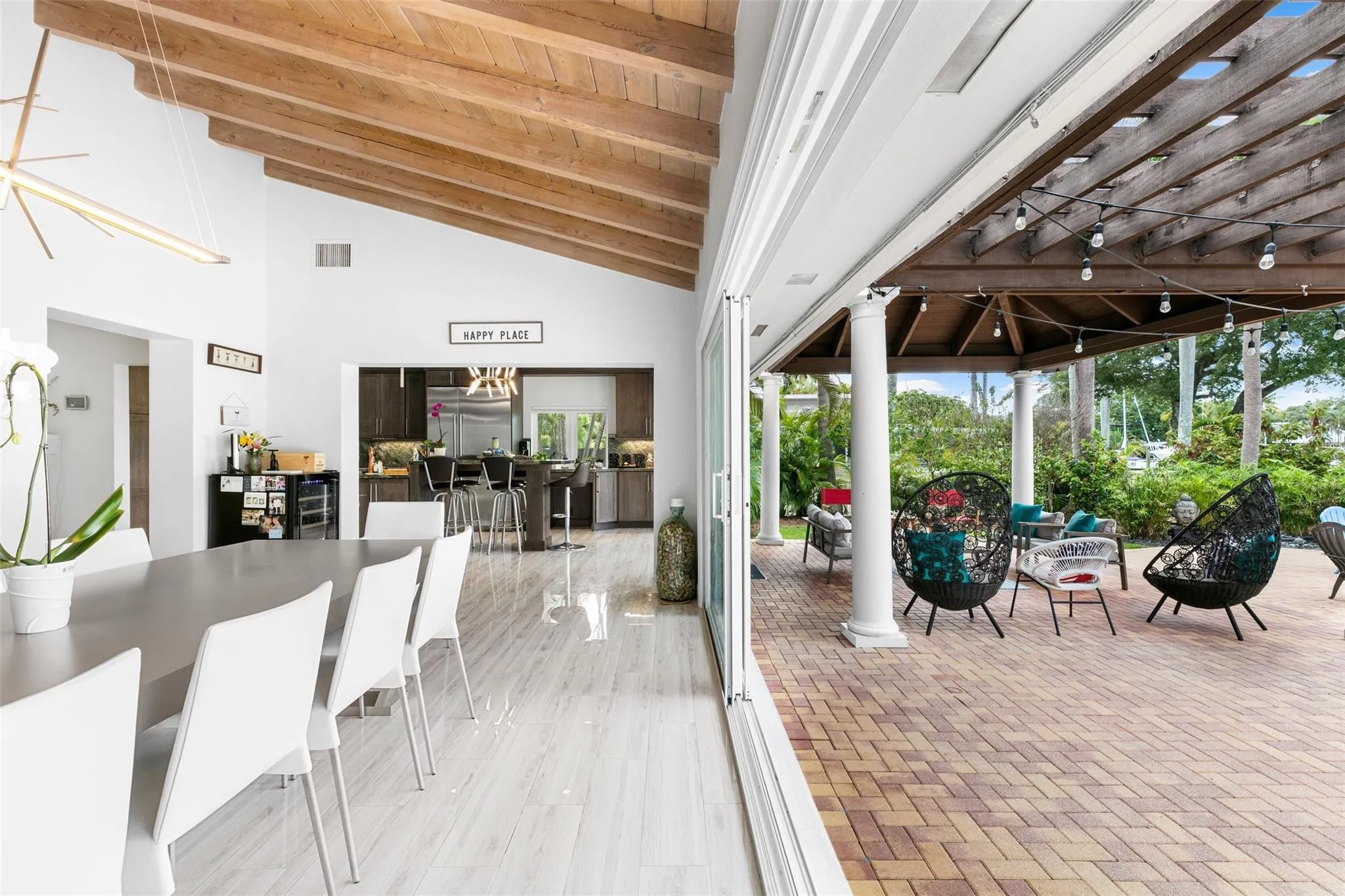 Vaulted wood-beamed ceiling over an open-concept living space with light wood-finish flooring