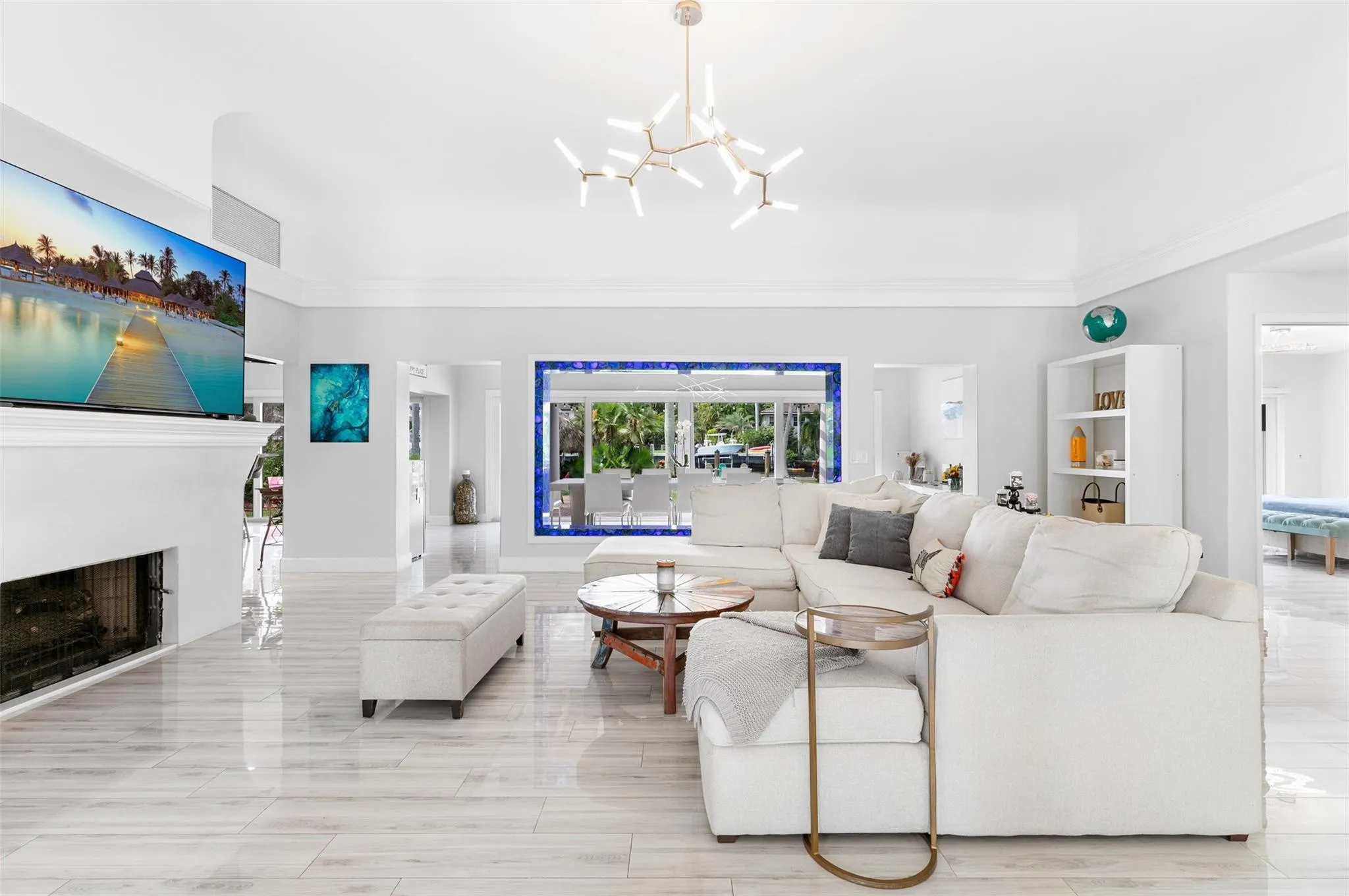 Spacious living area featuring high vaulted ceilings, light-tone wood-finish flooring, and a modern chandelier