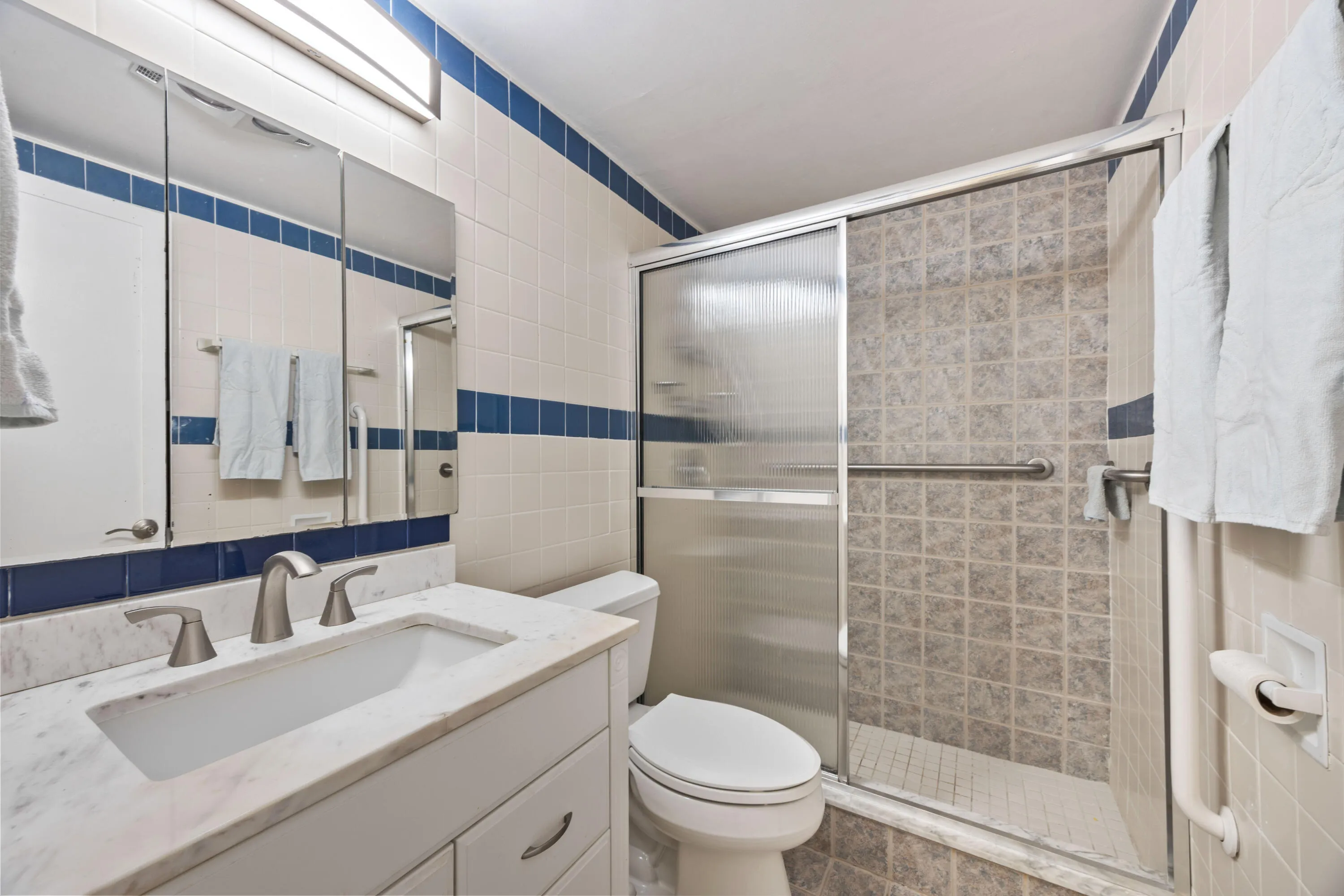 Tile to the ceiling, updated vanity, faucet & lighting