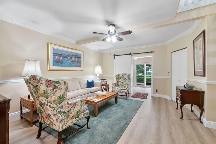 Living area featuring upgraded flooring and crown molding