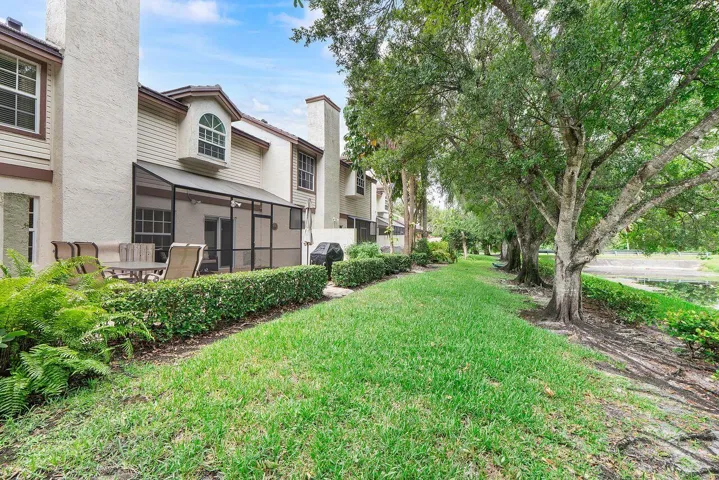 Exterior featuring a screened patio and adjacent paved terrace