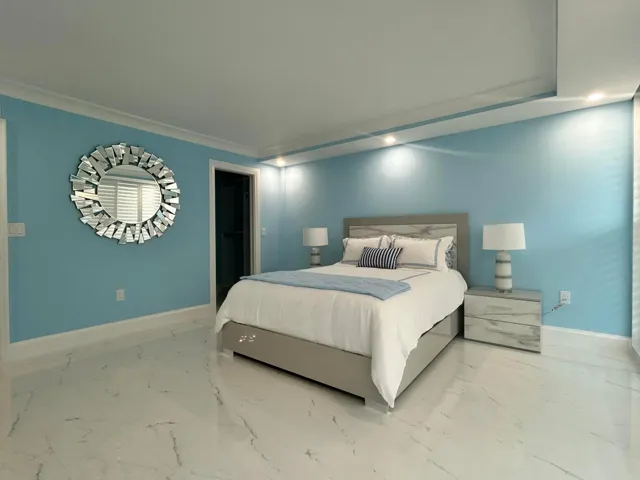 Guest bedroom, marble-look tile flooring, crown molding, and recessed lighting