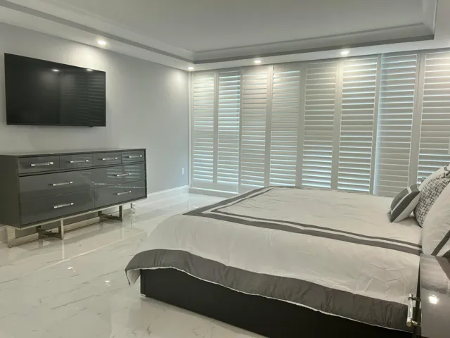 Full wall of white plantation shutters