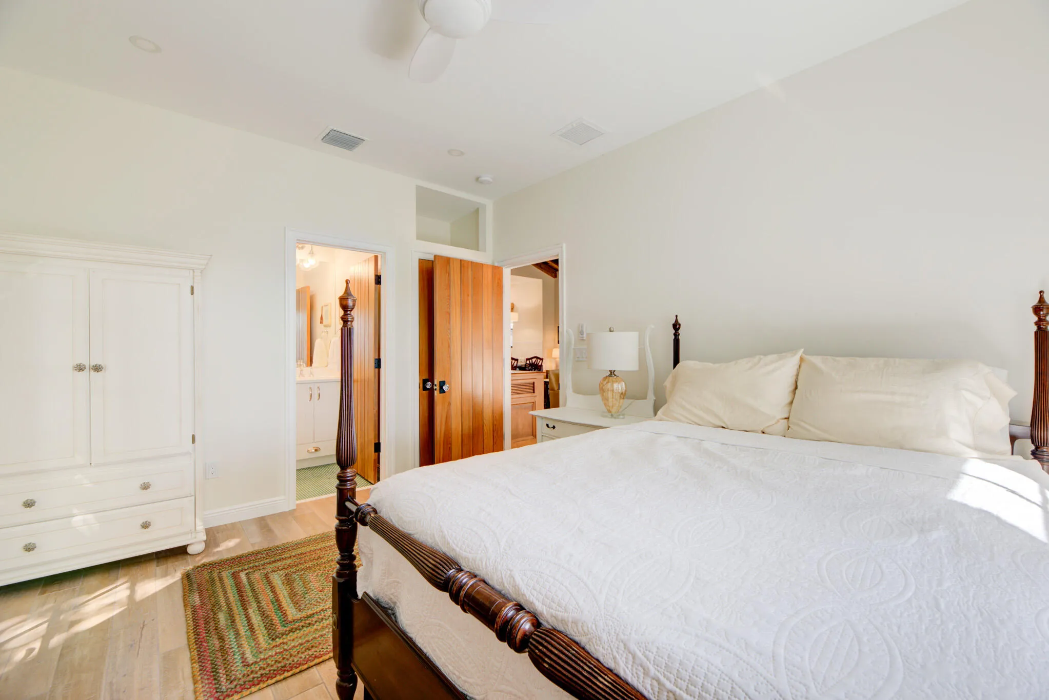 Spacious room featuring wood-finish flooring, a ceiling fan, recessed lighting, and a white armoire